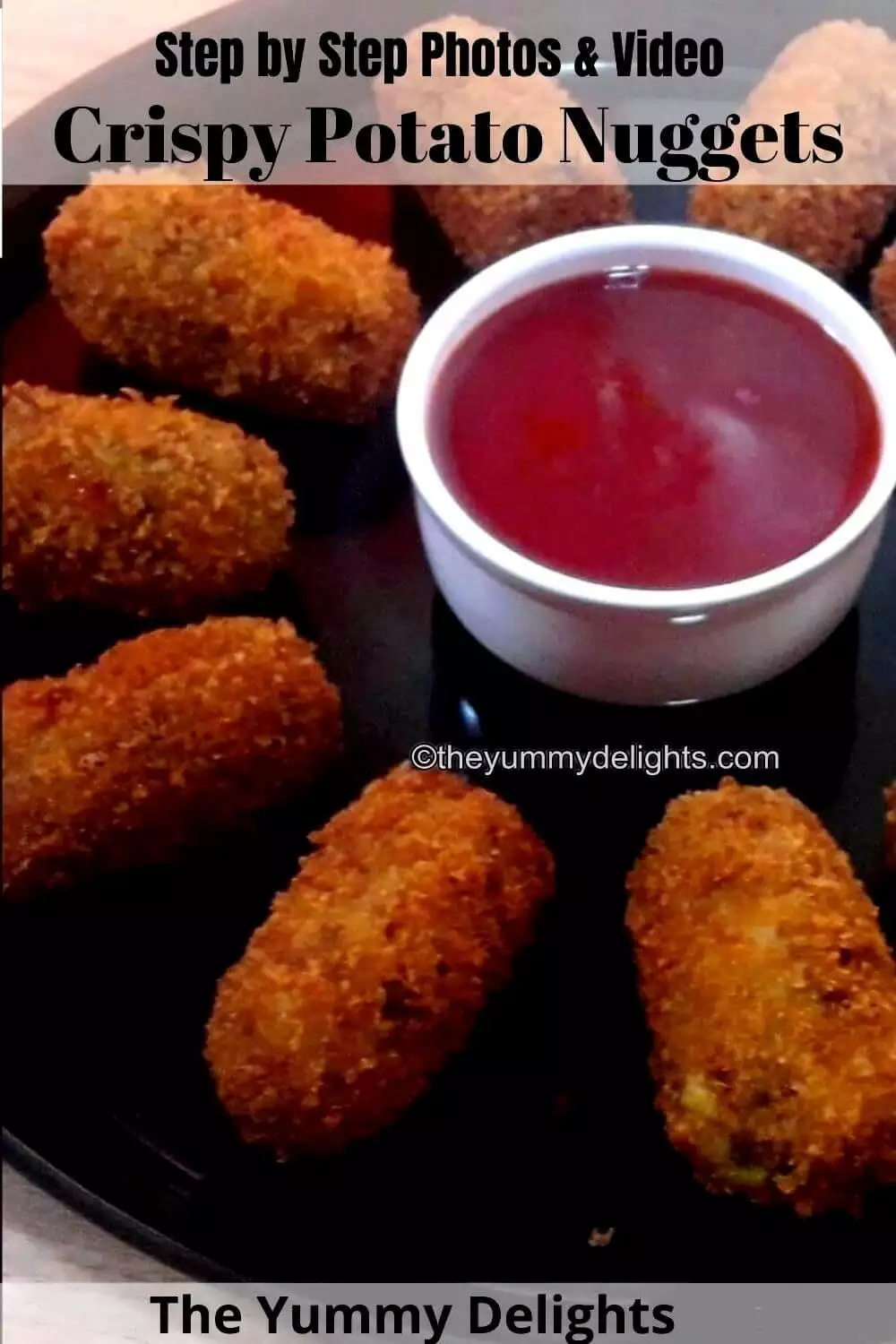 close-up of crispy potato nuggets served in a black colored plate.