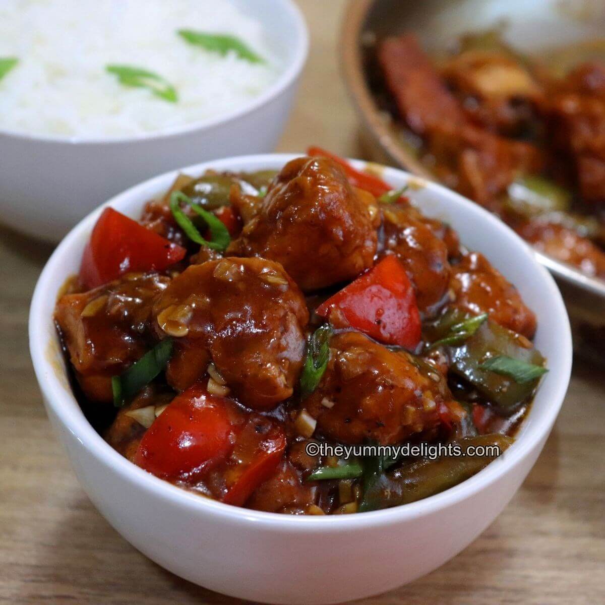 chili chicken served in a white bowl.