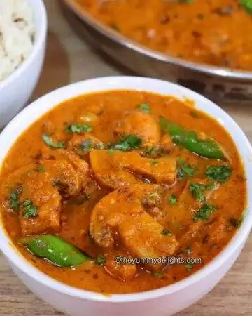 mushroom masala served in a white bowl. It is served with Jeera rice on the side.