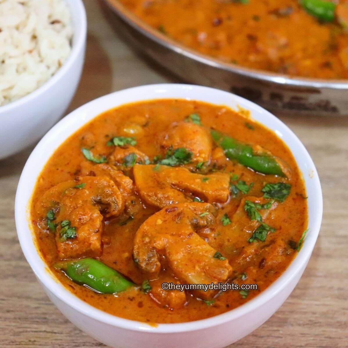 mushroom masala served in a white bowl. It is served with Jeera rice on the side.