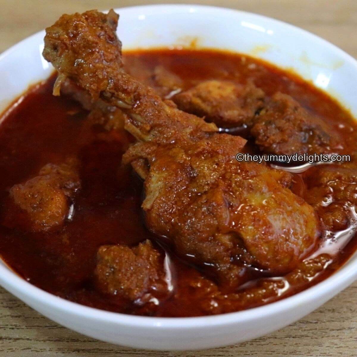 Malvani chicken curry served in a white bowl.