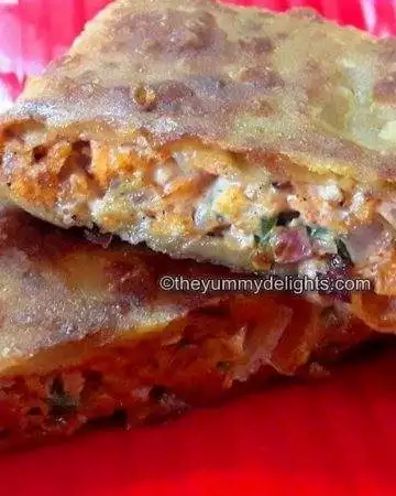 Mughlai egg paratha served on a red plate