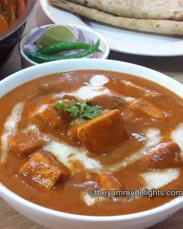 close up of paneer butter masala served with Roti & salad.