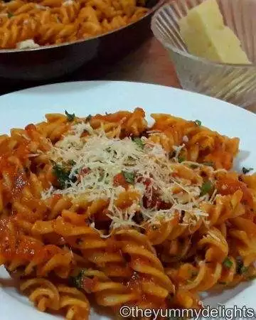 tomato pasta served in a white bowl.