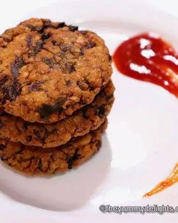 chana dal vada served in a white plate with tomato sauce.
