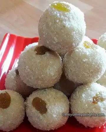 Maharashtrian style rava ladoo placed on a red plate. Garnished with raisins.