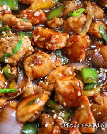 black pepper chicken stir-fry close-up image. Garnished with spring onion greens.