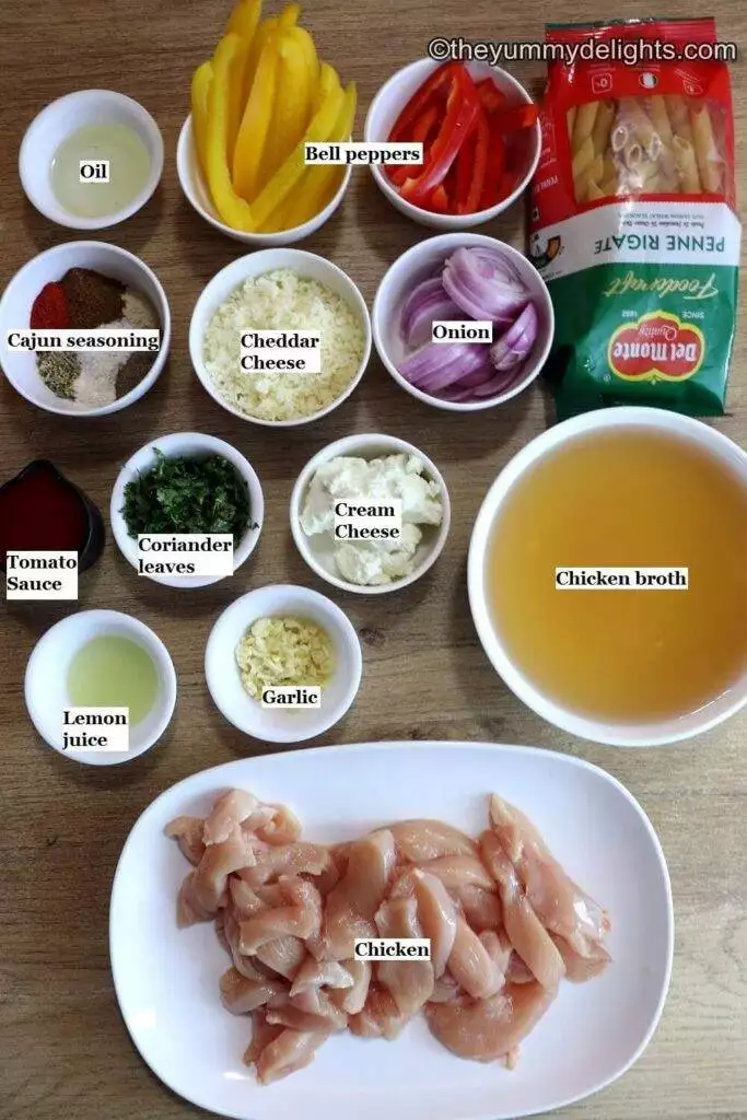 individually labeled ingredients to make creamy cajun chicken pasta laid on a table.