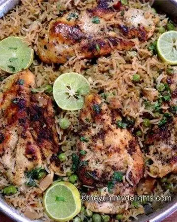 lemon chicken and rice in one pan garnished with lemon wedges and cilantro.