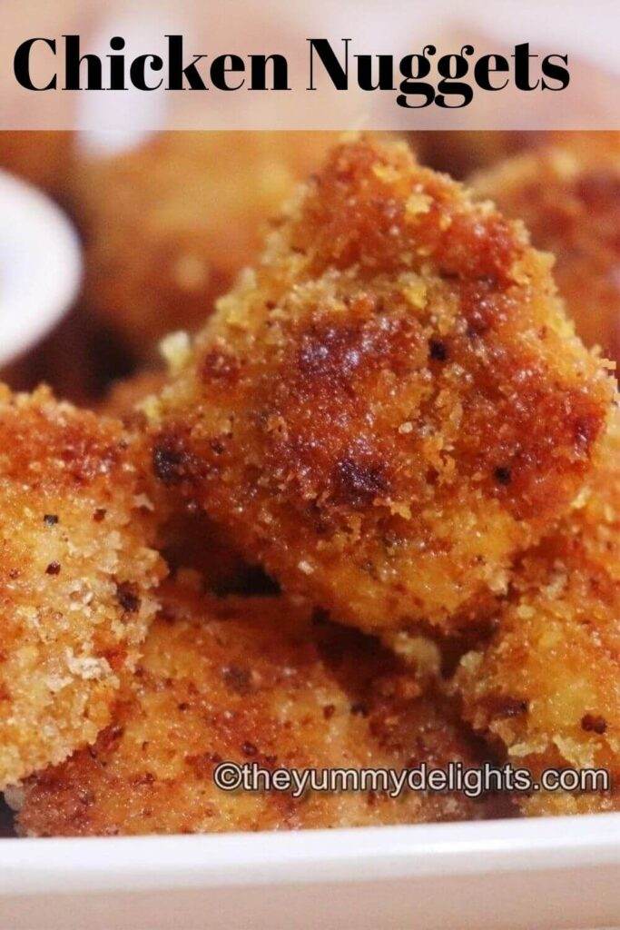 Image of crispy homemade chicken nuggets placed on a white plate.