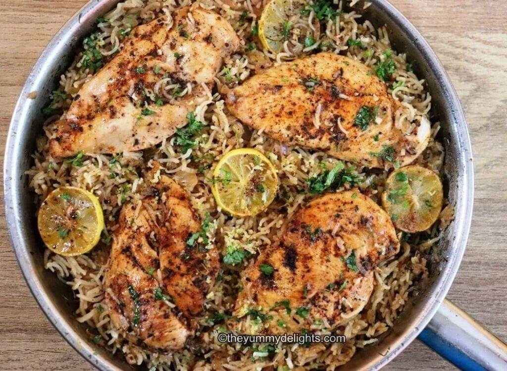 close-up of greek lemon chicken and rice in a skillet.