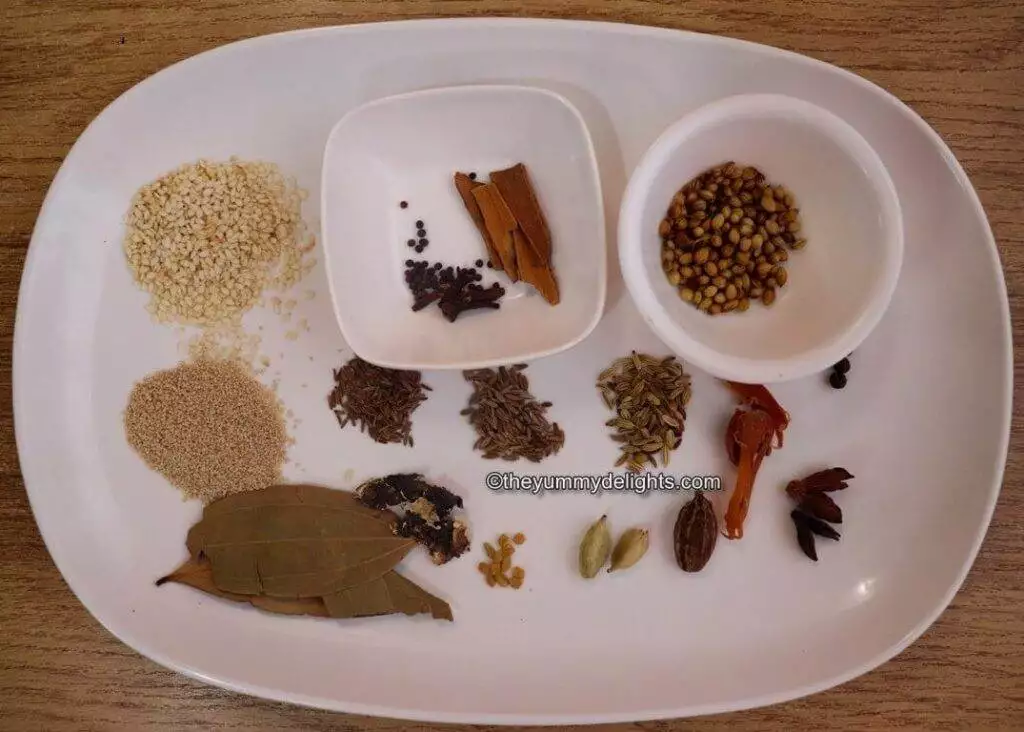 Ingredients to make Malvani chicken masala is shown on a white plate.