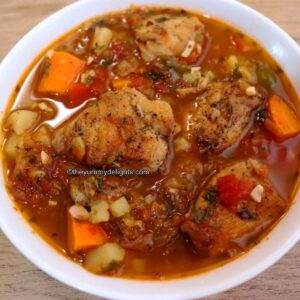 Mediterranean chicken stew served in a white bowl.