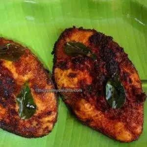Close-up of Andhra fish fry placed on a green color plate.