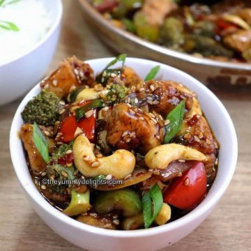 Close-up image of chicken and vegetable stir-fry in a white bowl.