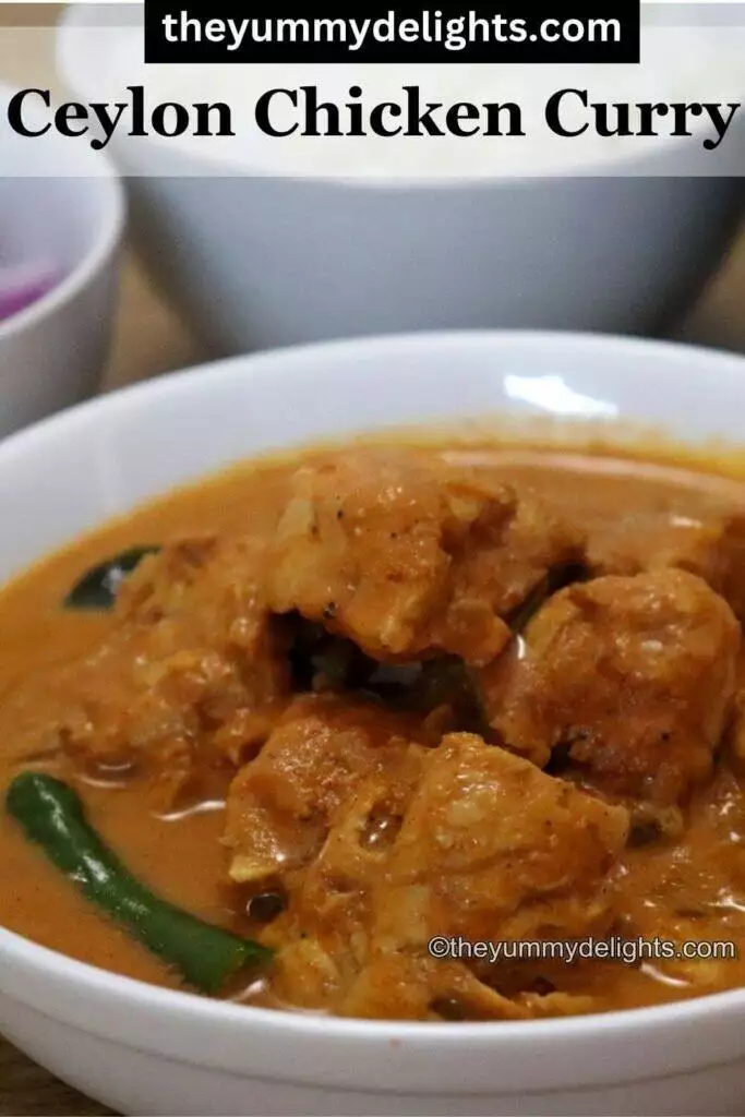 side view of ceylon chicken curry served in a white bowl. It is garnished with green chili and curry leaves.