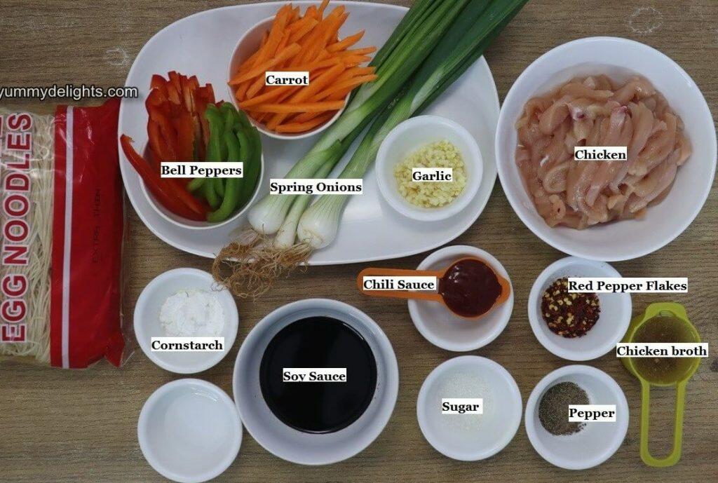 Individually labeled ingredients to make chicken chow mein is laid out on a table.