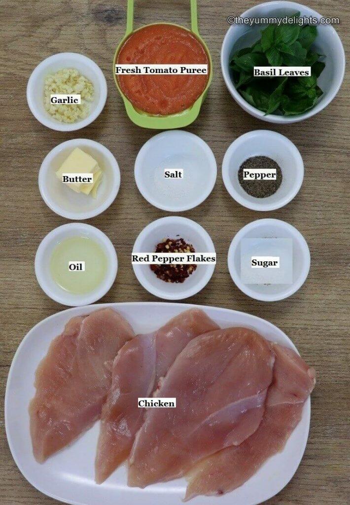 individually labeled ingredients to make tomato basil chicken pasta recipe are laid out on a table.