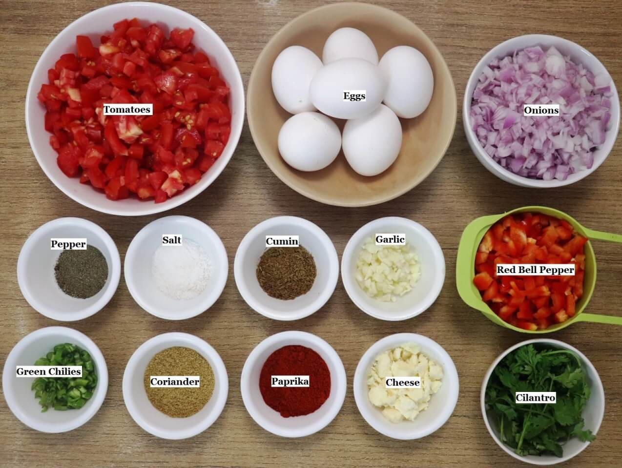 individually labeled ingredients to make spicy shakshuka recipe are laid out on a table.