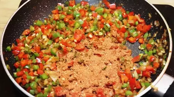 addition of Cajun seasoning to the sauteed vegetables.