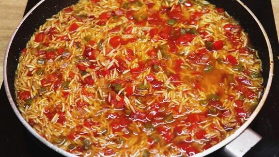 addition of water to cook rice in the pan.