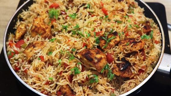picture of cajun chicken and rice in the pan. Garnished with cilantro.