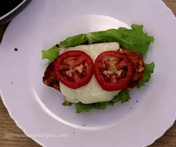 assembling chipotle chicken sandwich. It shows topping the buns with lettuce leaves, chicken and tomatoes.