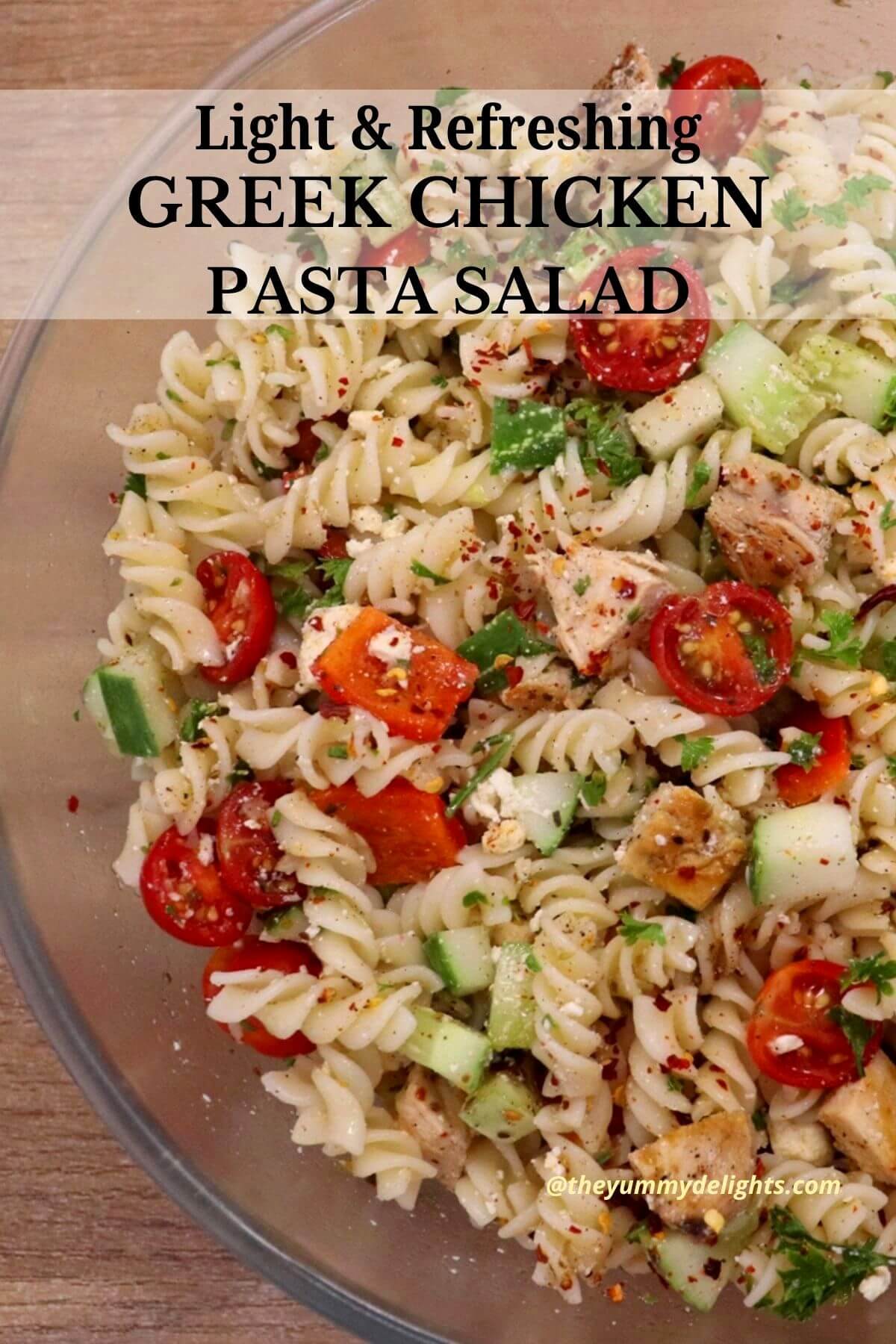 side view of greek chicken pasta salad in a bowl.