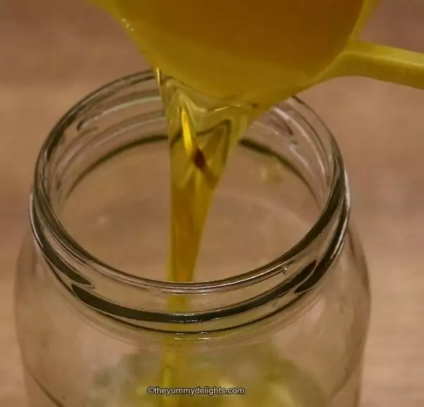 making greek dressing. Pouring olive oil in a jar.