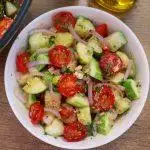 close-up of mediterranean cucumber tomato salad in a white colored bowl.