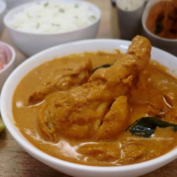 close-up of mangalorean chicken curry (kori gassi) served in a white colored bowl.