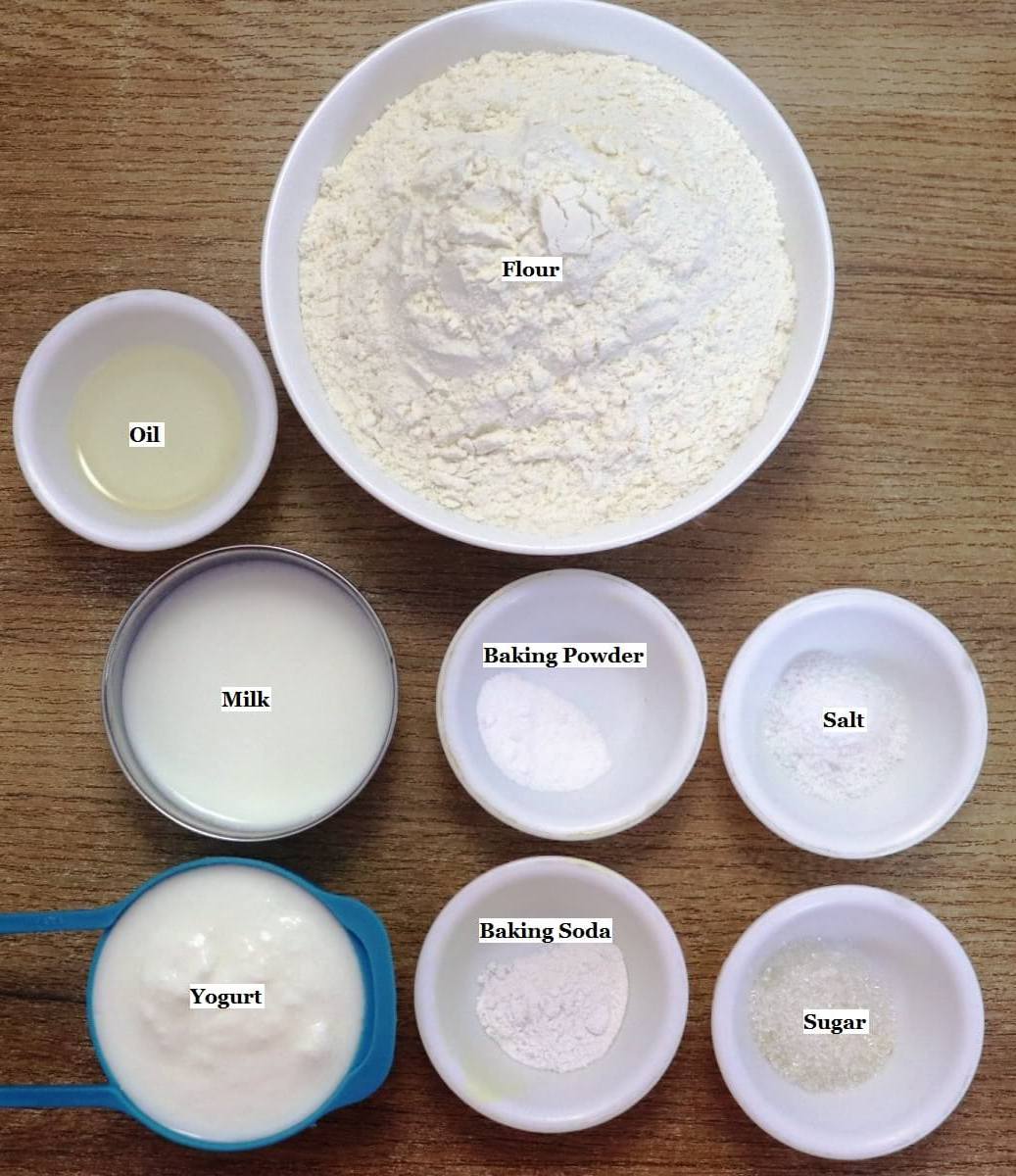 individually labeled ingredients to make naan bread recipe with yogurt are laid out on a table.