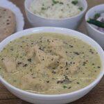 close-up of chicken kali mirch served in a white bowl. Garnished with freshly crushed black pepper.