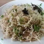 Close-up image of jeera rice served on a plate.