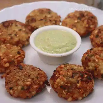 sabudana vadas served on a white plate with green coconut chutney.