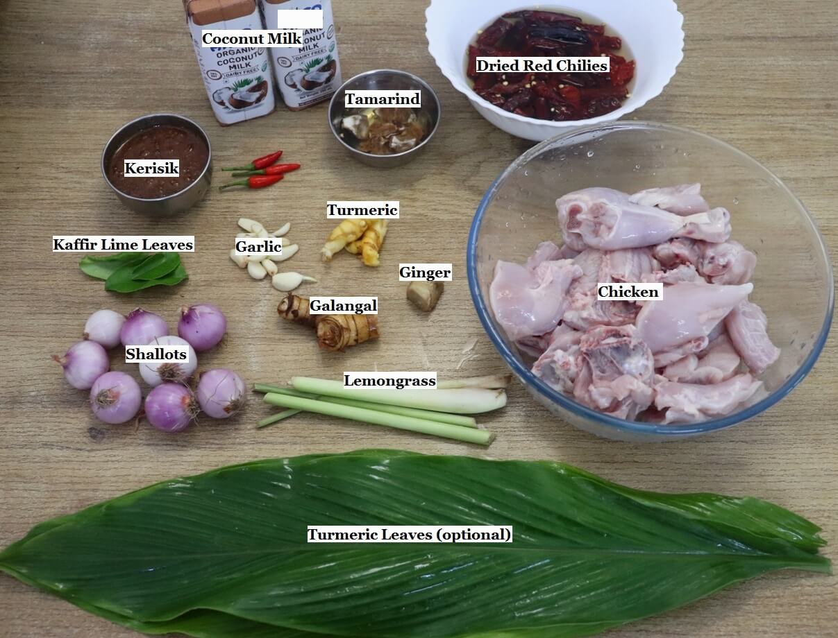 individually labeled ingredients to make chicken rendang recipe are laid out on a table.