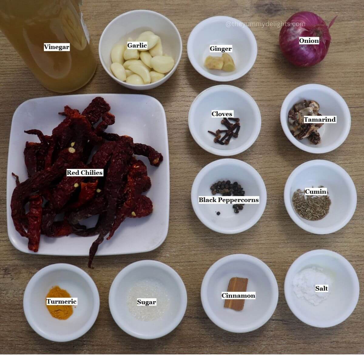 individually labeled ingredients to make goan recheado masala are laid out on a table.