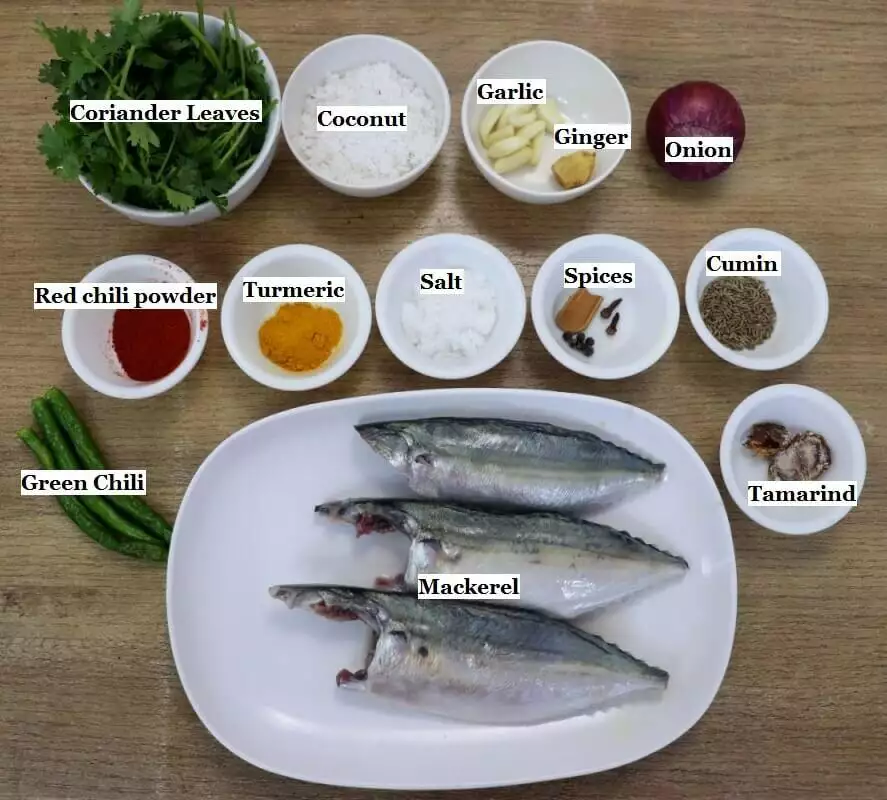 individually labeled ingredients to make stuffed mackerel fish recipe are laid out on a table.