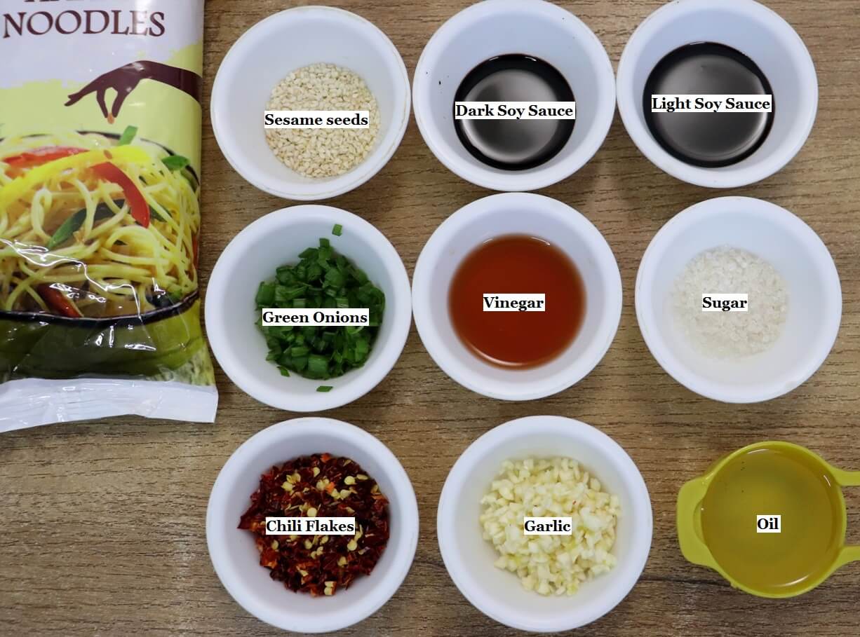 individually labeled ingredients to make chili oil noodles recipe are laid out on a table.