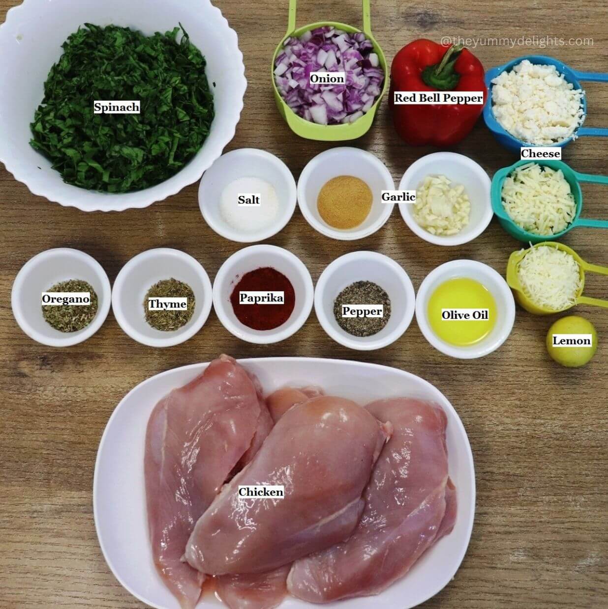 individually labeled ingredients to make mediterranean stuffed chicken breast recipe are laid out on a table