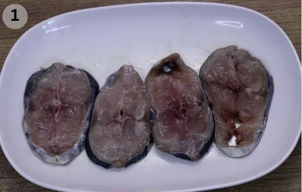 4 kingfish fillets placed on a white plate.