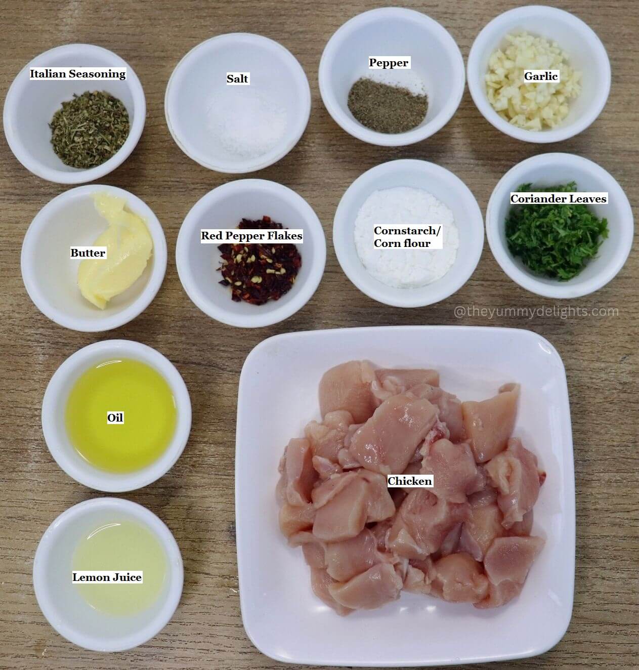 individually labeled ingredients to make garlic butter chicken bites recipe are laid out on a table.