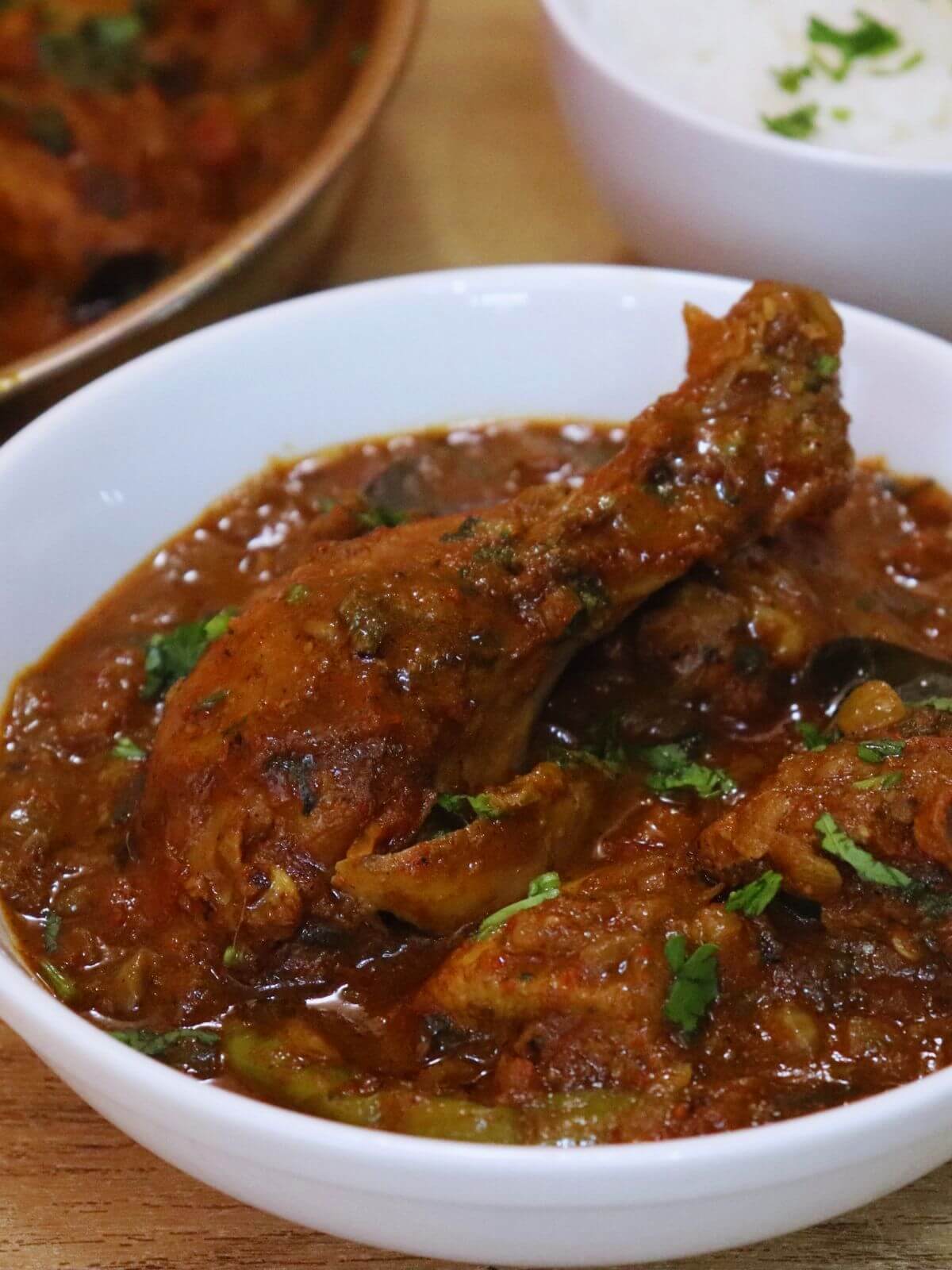 close-up of andhra chicken curry served in a white bowl.