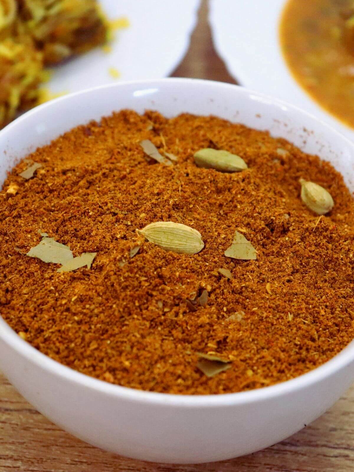 close-up of biryani masala powder in a white color bowl.