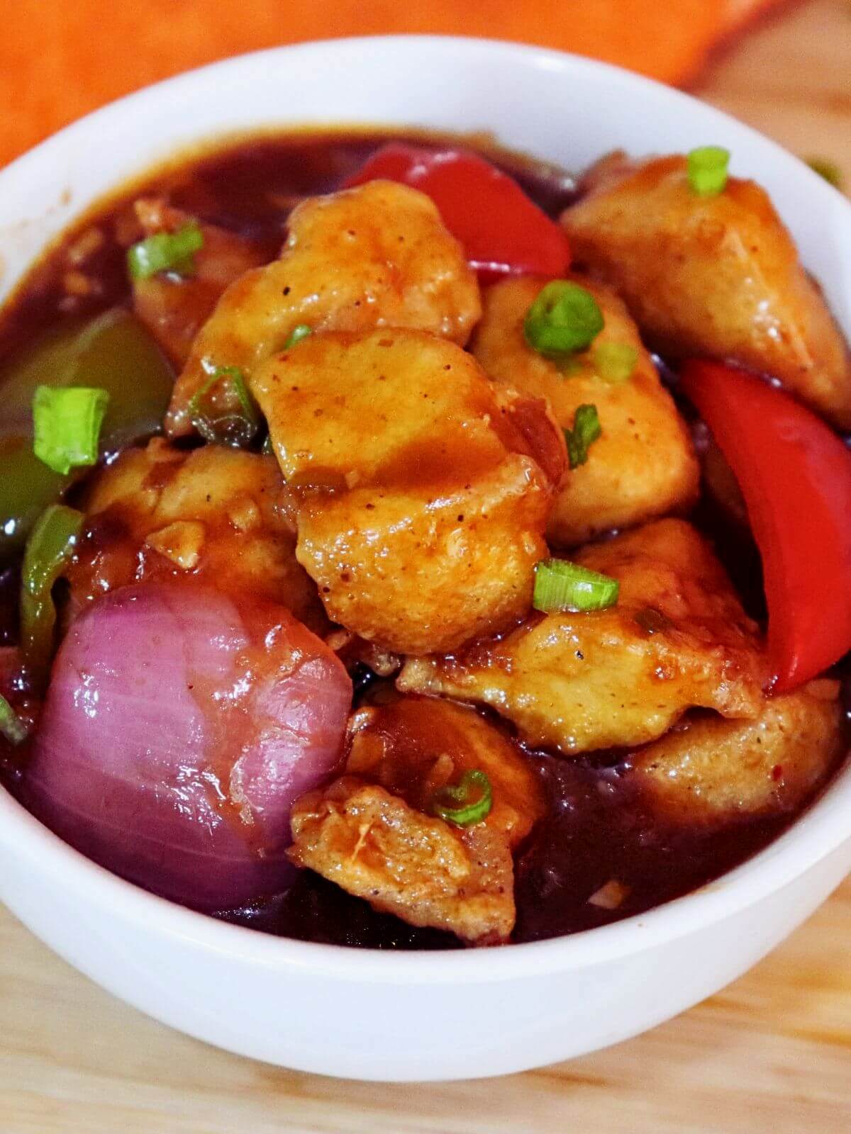 close-up of chicken manchurian gravy in a white bowl.