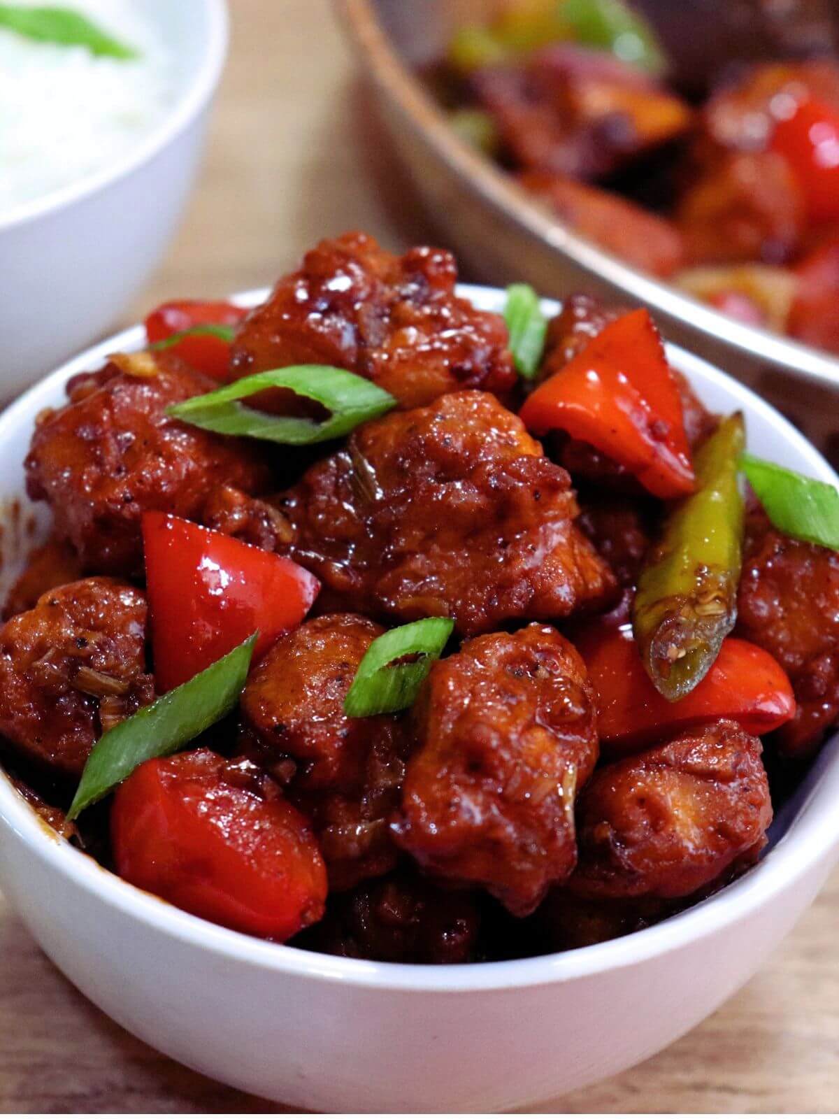 tight close-up of chilli chicken served in a bowl.