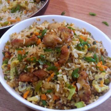 chicken fried rice served in a white bowl.