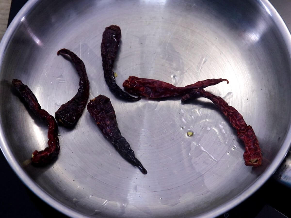 roasting red chilies to make egg drop curry masala.