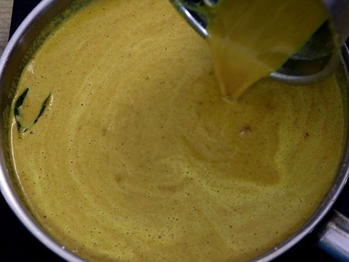 addition of water to adjust the consistency of the egg curry.