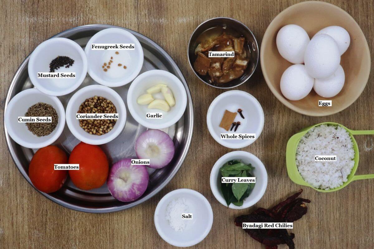 individually labeled ingredients to make mangalorean egg drop curry are laid out on a table.
